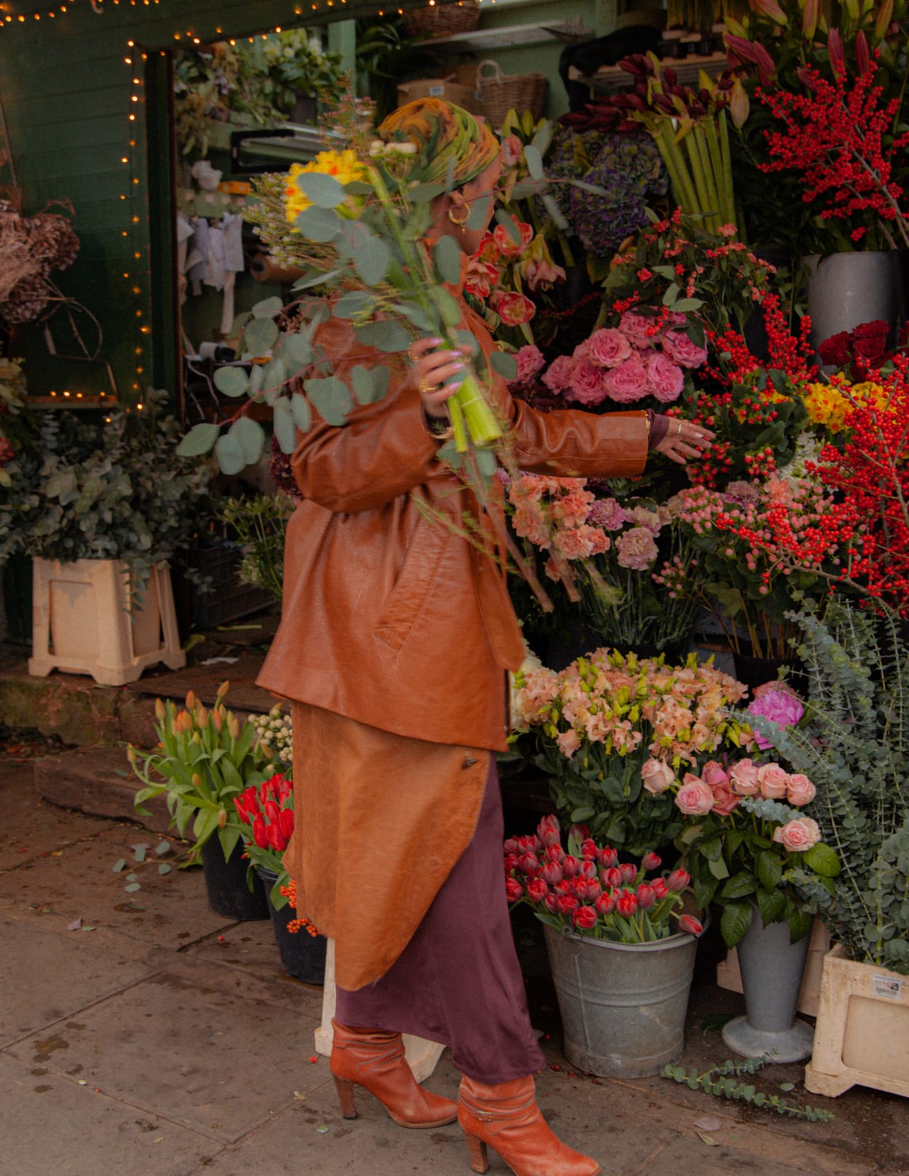 A finished bouquet wrapped in brown paper, carried in afternoon light