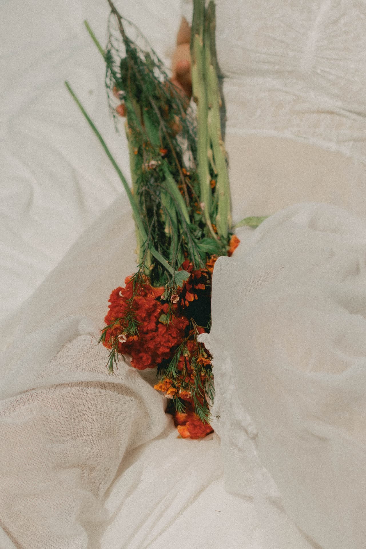 A bouquet of marigolds resting on white linen